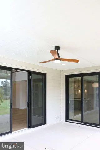 a view of a room with wooden floors and kitchen view