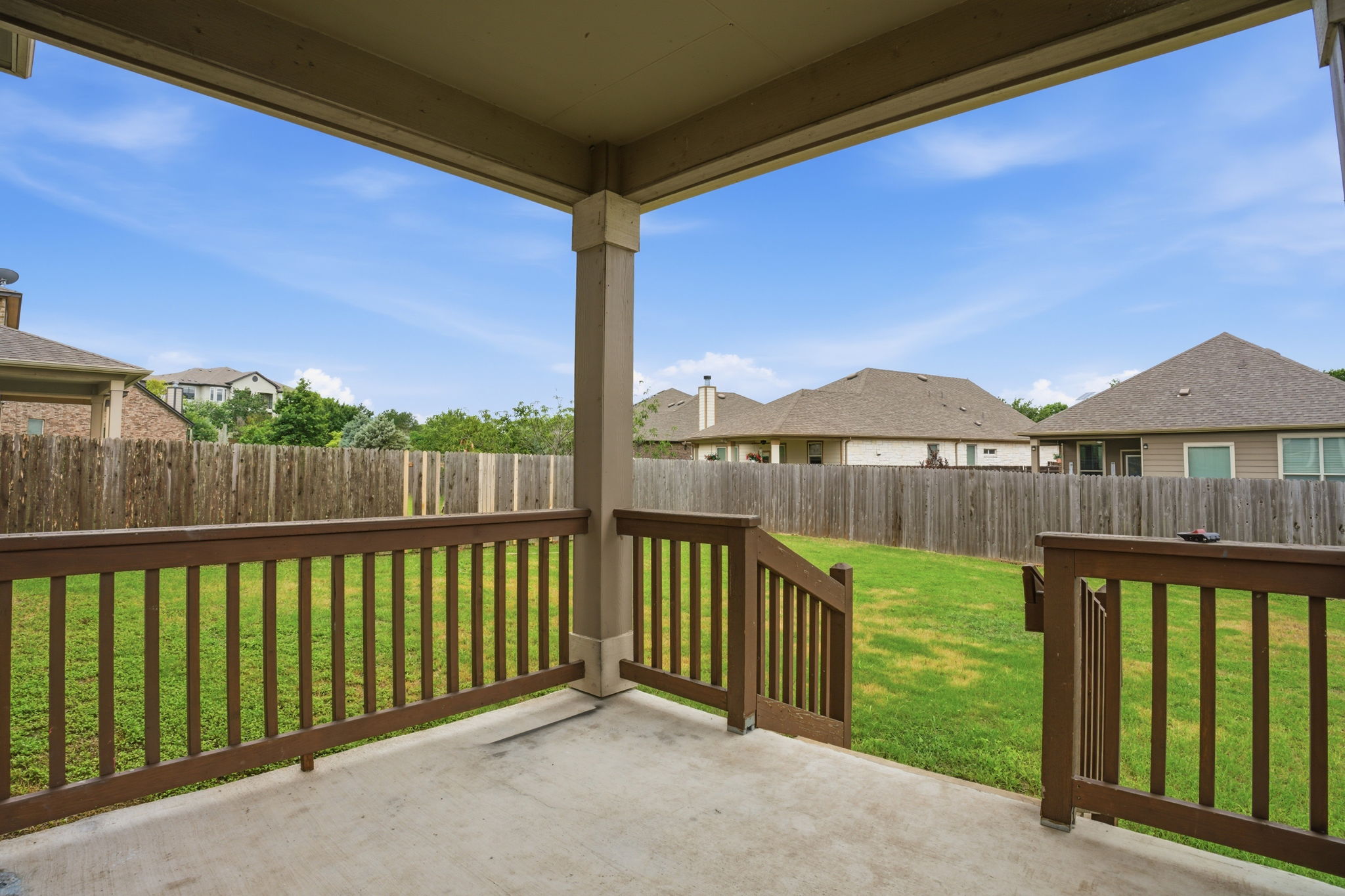 670 Landon Samuel Loop Pflugerville, TX 78660 - Photo 20 of 22 Covered patio with concrete flooring and dark wood-tone railings