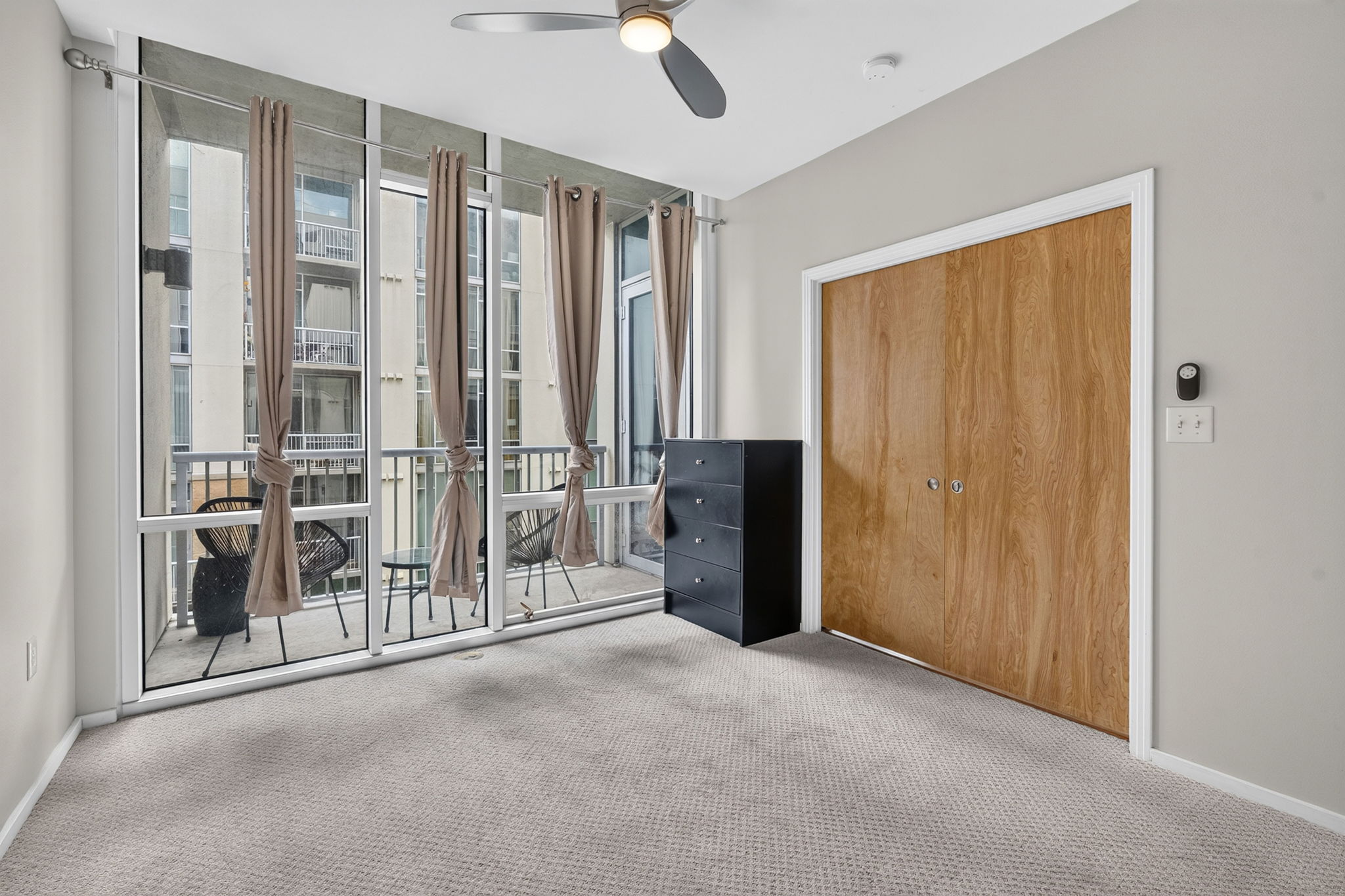 1600 Barton Springs Road, Unit 1302 Austin, TX 78704 - Photo 2 of 15 Floor-to-ceiling windows fill this carpeted space with natural light.