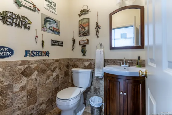 a bathroom with a granite countertop toilet sink and mirror