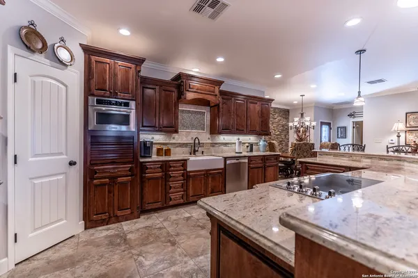 a kitchen with kitchen island granite countertop stainless steel appliances and wooden cabinets
