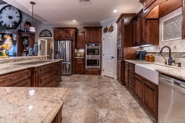 a kitchen with stainless steel appliances kitchen island granite countertop a refrigerator and a stove top oven