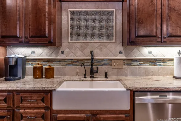 a kitchen with granite countertop a sink a stove and cabinets