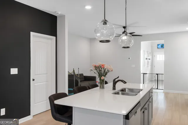 a kitchen with stainless steel appliances granite countertop a sink a refrigerator and chandelier