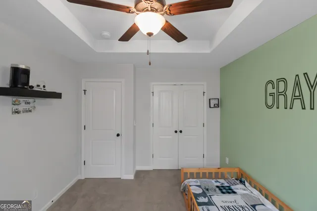 a view of backyard with large trees and wooden fence
