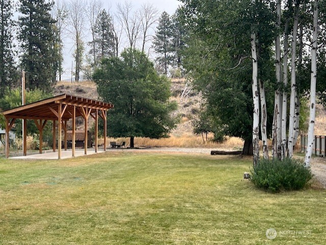 29 Twisp Airport Road Twisp, WA 98856 - Photo 11 of 19 a view of a swimming pool with lawn chairs under an umbrella