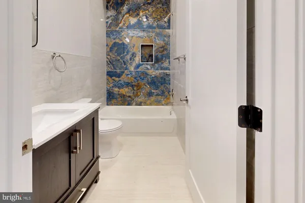 a spacious bathroom with a granite countertop sink a toilet and shower