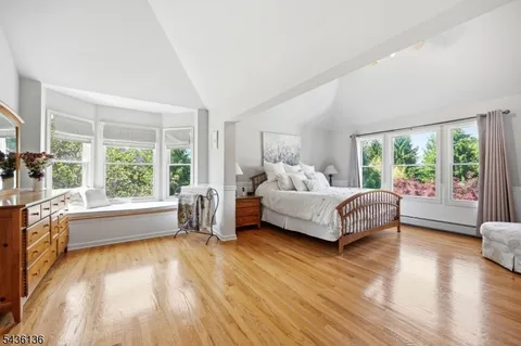 a bedroom with a bed and a large window with outer view