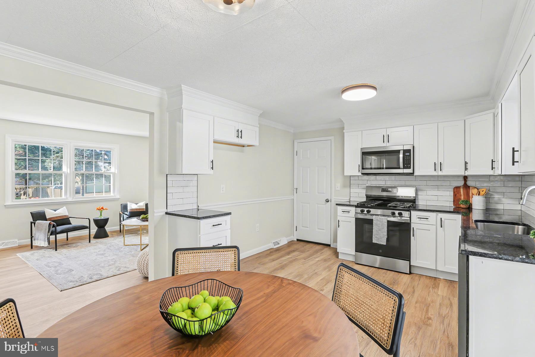 233 Cardinal Road Lititz, PA 17543 - Photo 11 of 26 a kitchen with stainless steel appliances granite countertop a stove top oven a sink dishwasher a dining table and chairs with wooden floor
