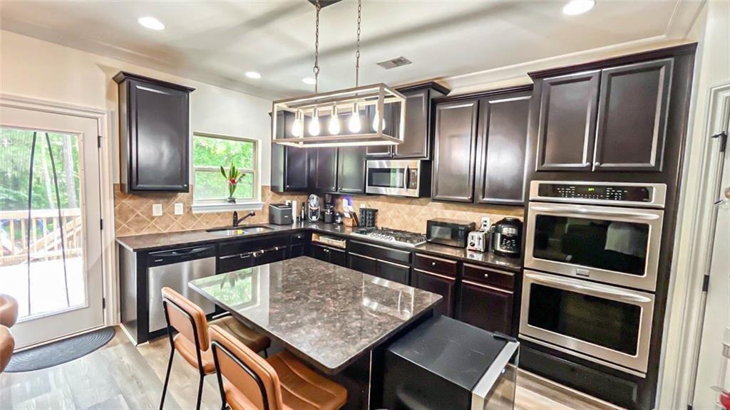 3281 Alhambra Circle Hampton, GA 30228 - Photo 24 of 88 a kitchen with kitchen island granite countertop stainless steel appliances and a counter space