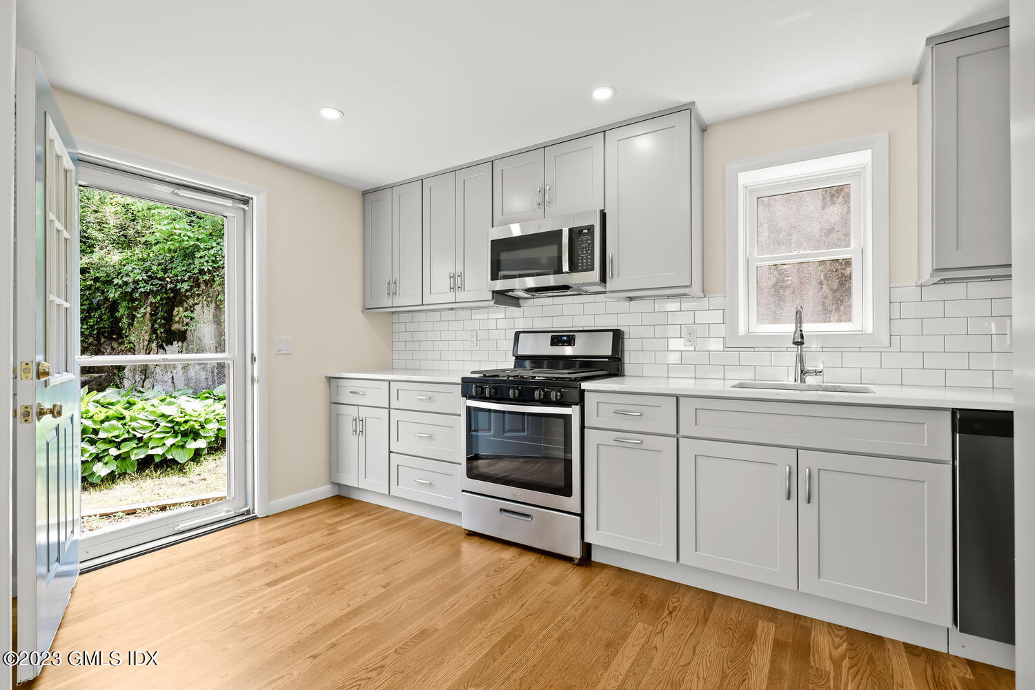 248 Byram Road, Unit L Greenwich, CT 06830 - Photo 5 of 14 a kitchen with stainless steel appliances granite countertop a stove a sink and a microwave