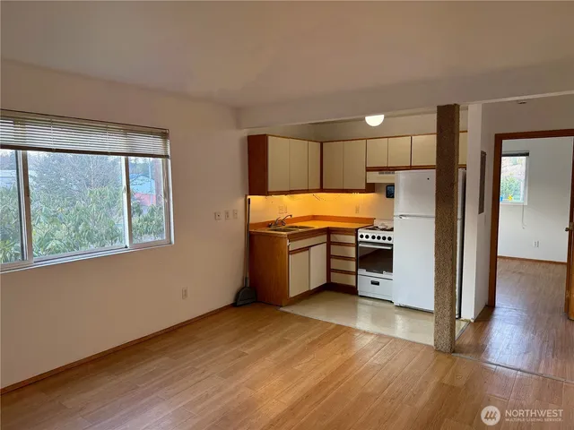 a kitchen with stainless steel appliances granite countertop a refrigerator a stove and a sink with wooden floor