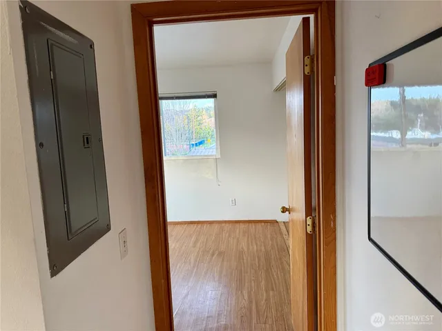 an empty room with wooden floor and windows