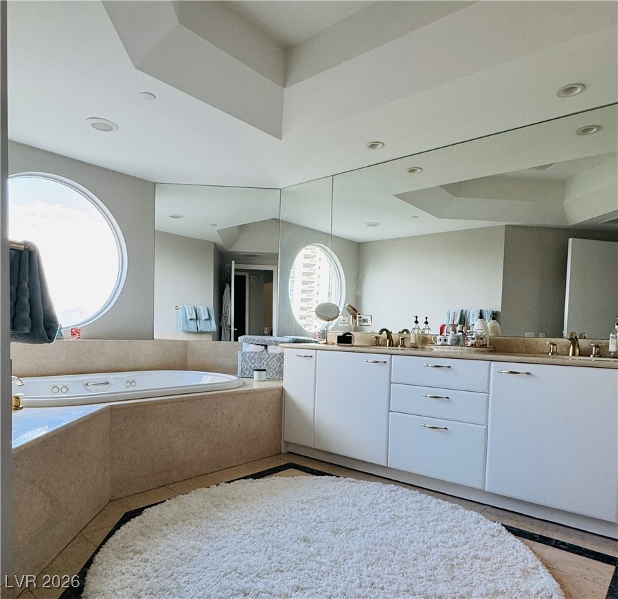 2857 Paradise Road, Unit 904 Las Vegas, NV 89109 - Photo 12 of 27 Full bath with a tray ceiling, double vanity, light tile patterned floors, a bath, and recessed lighting