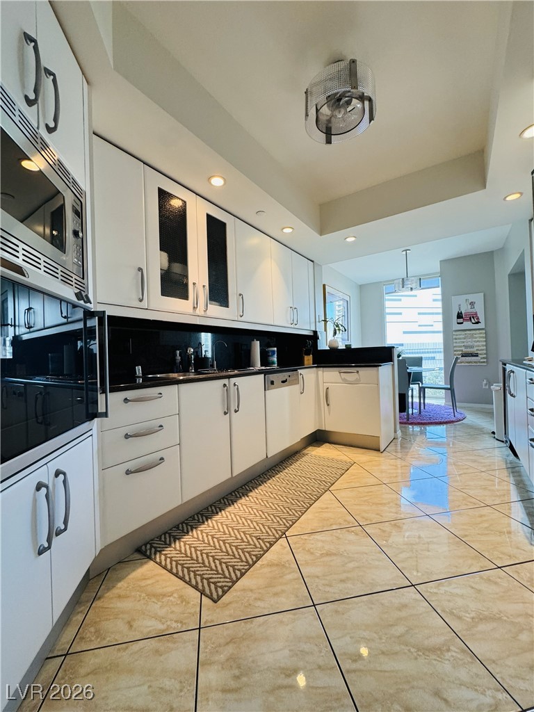 2857 Paradise Road, Unit 904 Las Vegas, NV 89109 - Photo 6 of 27 Kitchen featuring white cabinetry, recessed lighting, stainless steel microwave, pendant lighting, and black oven