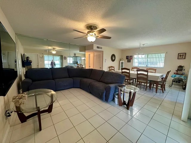 a living room with furniture a dining table and a chandelier