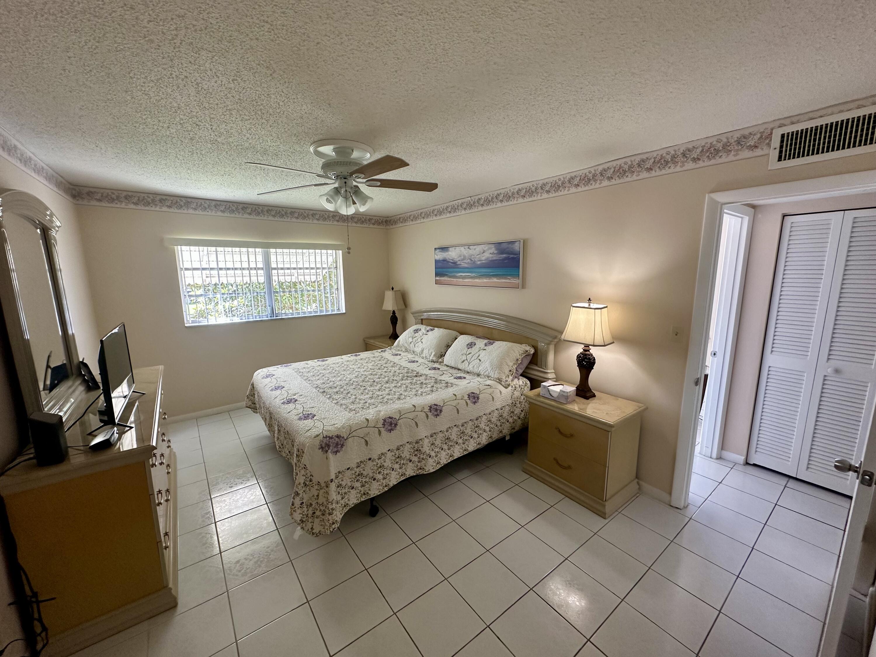 5300 Washington Street, Unit L240 Hollywood, FL 33021 - Photo 4 of 8 a bedroom with a bed and a chandelier