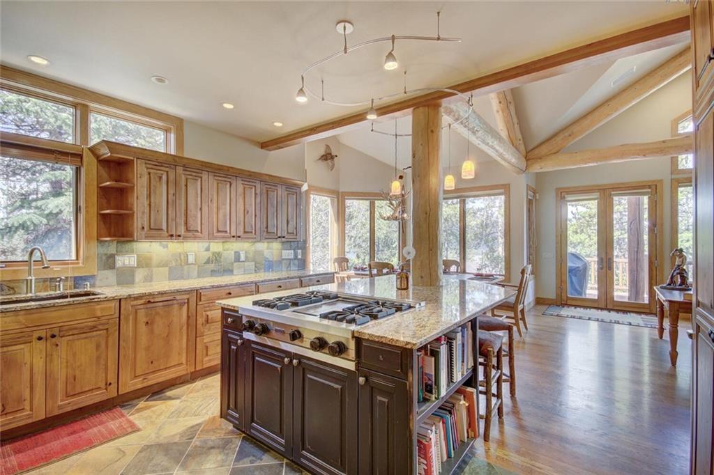 265 Mountain Bluebell Road Keystone, CO 80435 - Photo 28 of 35 a kitchen with stainless steel appliances granite countertop a stove a sink dishwasher and a dining table with wooden floor
