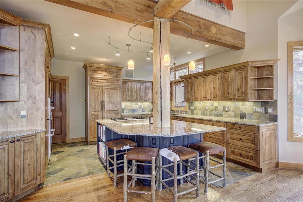 265 Mountain Bluebell Road Keystone, CO 80435 - Photo 30 of 35 a room with stainless steel appliances kitchen island granite countertop a table chairs sink and cabinets