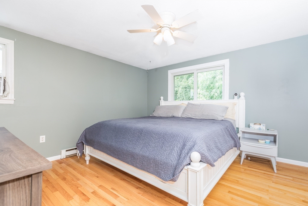 4 Acadia Kimball Road, Unit 4 Amesbury, MA 01913 - Photo 11 of 20 a bed room with a bed and a chandelier