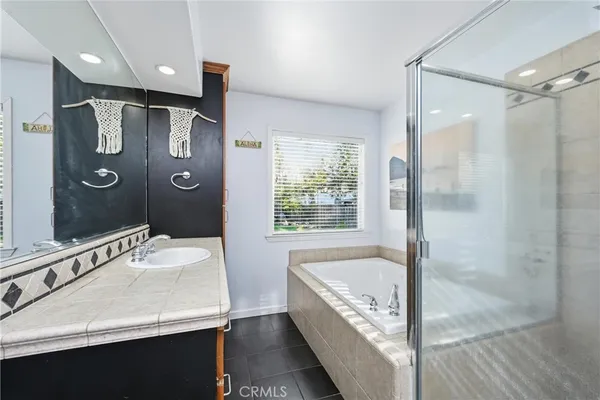 a bathroom with a tub a sink and mirror