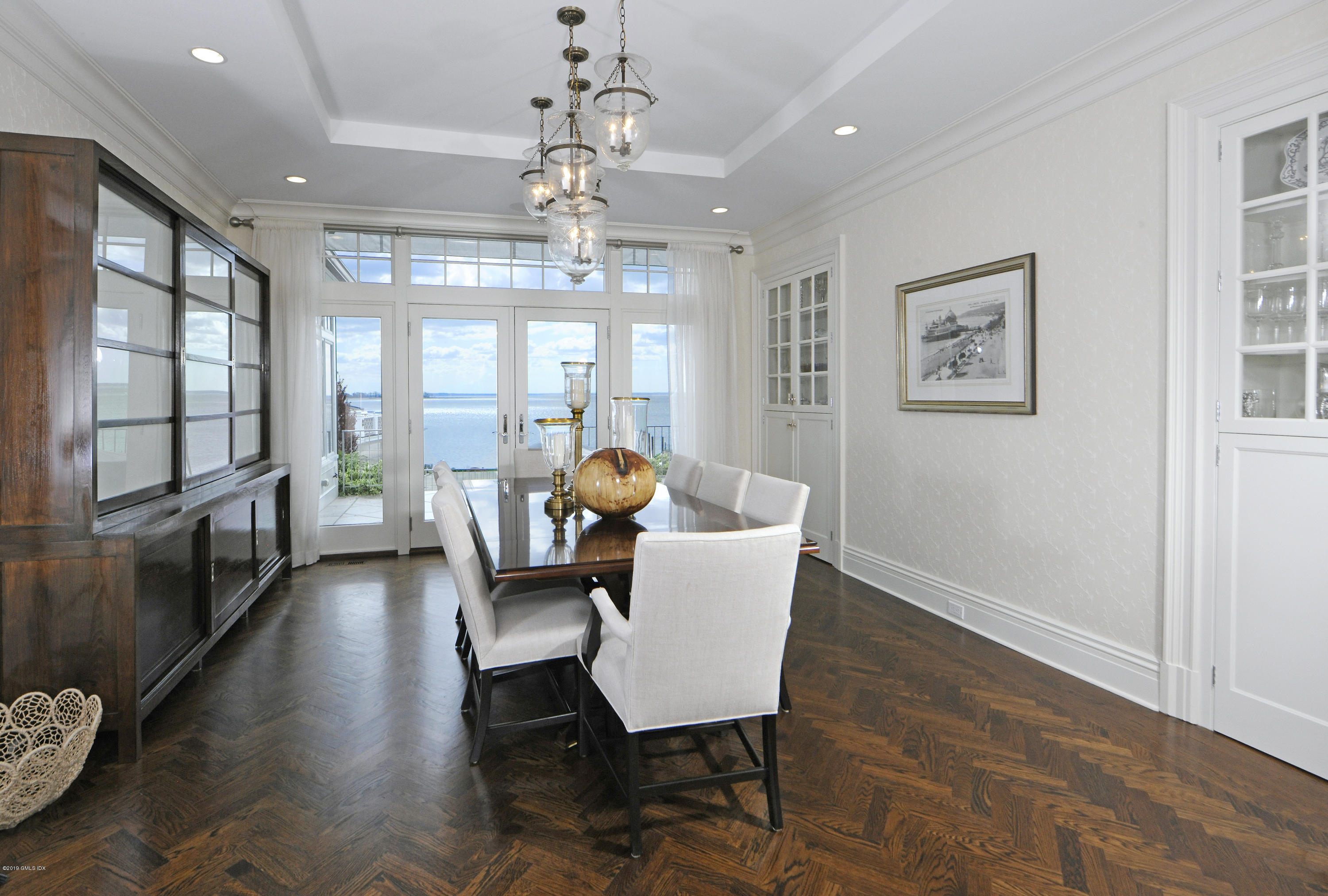 215 Byram Shore Road Greenwich, CT 06830 - Photo 4 of 26 a view of a dining room with furniture a chandelier and wooden floor
