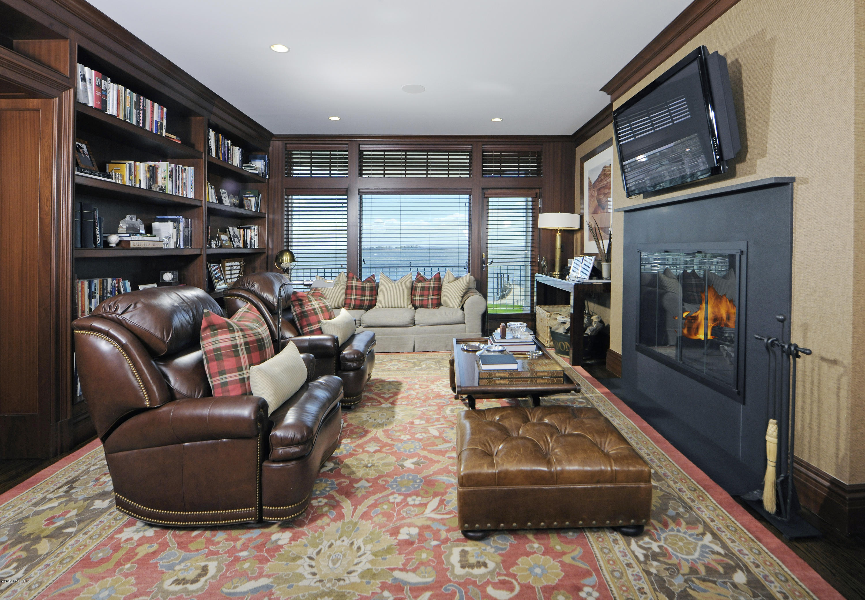 215 Byram Shore Road Greenwich, CT 06830 - Photo 8 of 26 a living room with furniture a flat screen tv and a fireplace