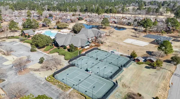 an aerial view of a house with swimming pool garden and trees