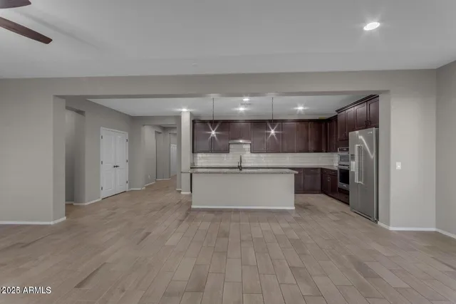 a large kitchen with stainless steel appliances kitchen island a large counter top and a refrigerator