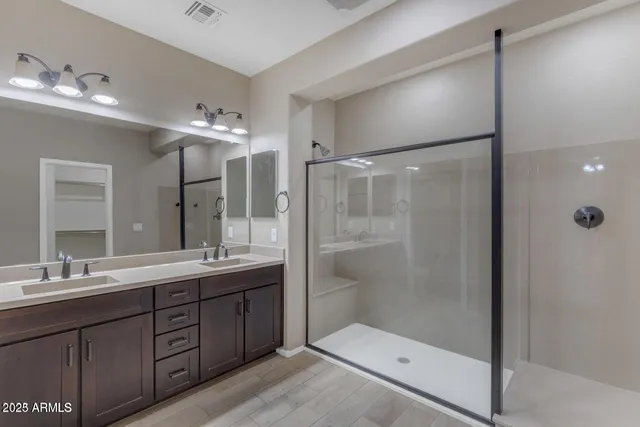 a bathroom with a double vanity sink mirror and shower