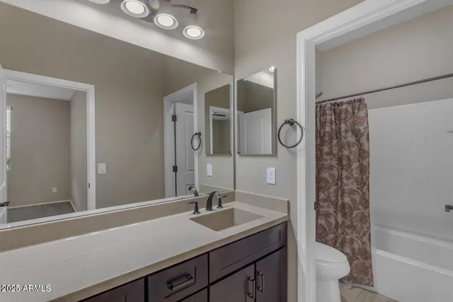 a bathroom with a sink a toilet a shower and a mirror