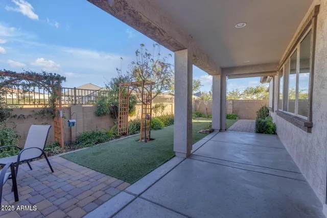 a view of a porch with chairs and table next to a yard