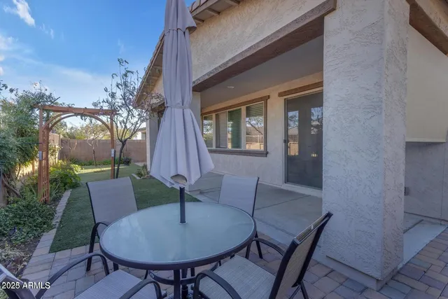a backyard of a house with table and chairs