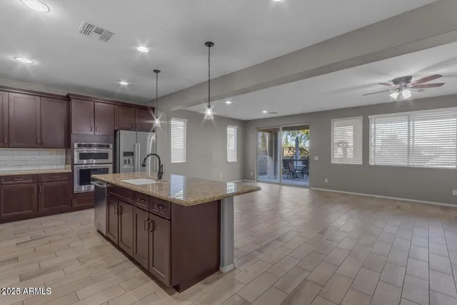 a kitchen with kitchen island granite countertop a sink counter top space appliances and cabinets