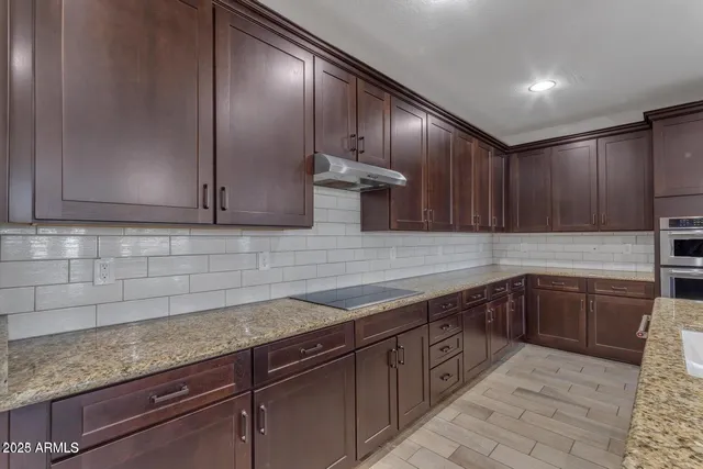 a kitchen with stainless steel appliances granite countertop a sink and cabinets