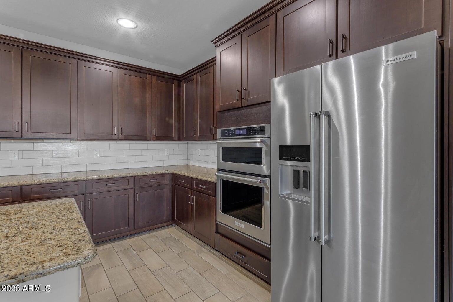 22841 South 225th Place Queen Creek, AZ 85142 - Photo 7 of 34 a kitchen with stainless steel appliances granite countertop a refrigerator and a stove top oven