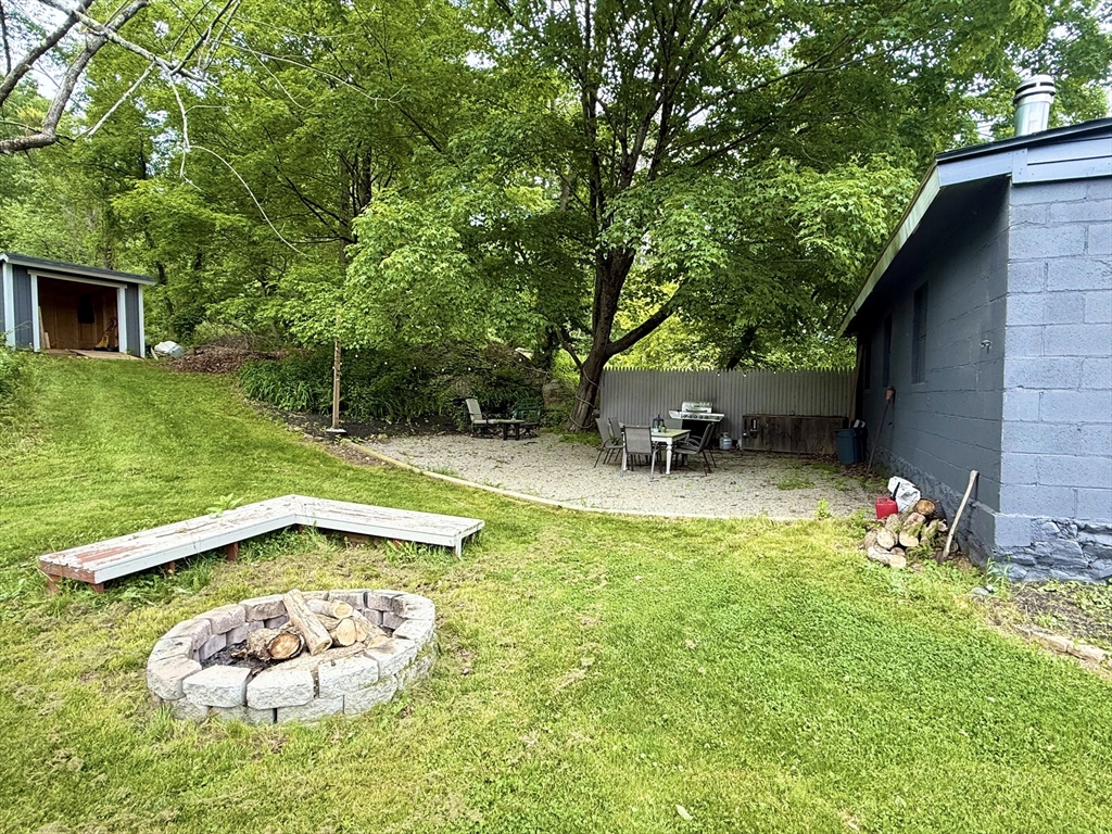 59 Brookfield Road Sturbridge, MA 01518 - Photo 38 of 40 a view of a backyard with table and chairs potted plants and large tree