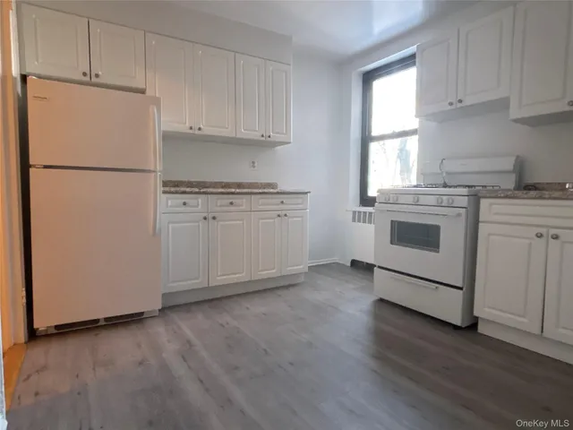 a kitchen with cabinets appliances and wooden floor