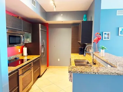 a kitchen with stainless steel appliances granite countertop a sink and a refrigerator