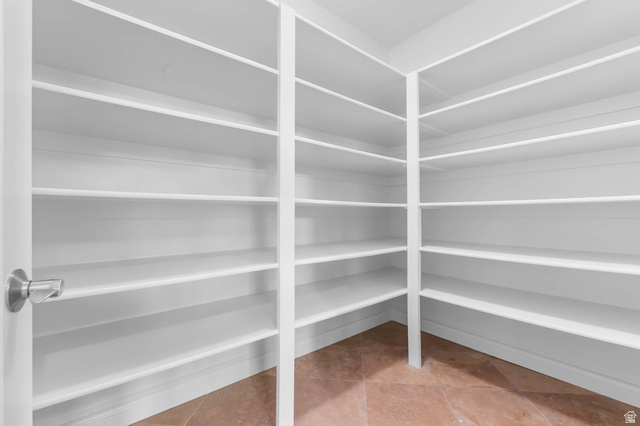 439 East 13540 South Draper, UT 84020 - Photo 12 of 46 Spacious walk-in pantry featuring extensive white shelving, tile flooring, and a contemporary doorknob