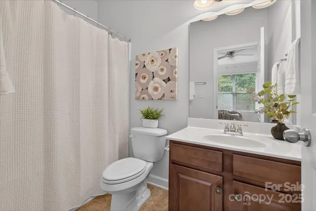 a bathroom with a sink a toilet and shower curtain