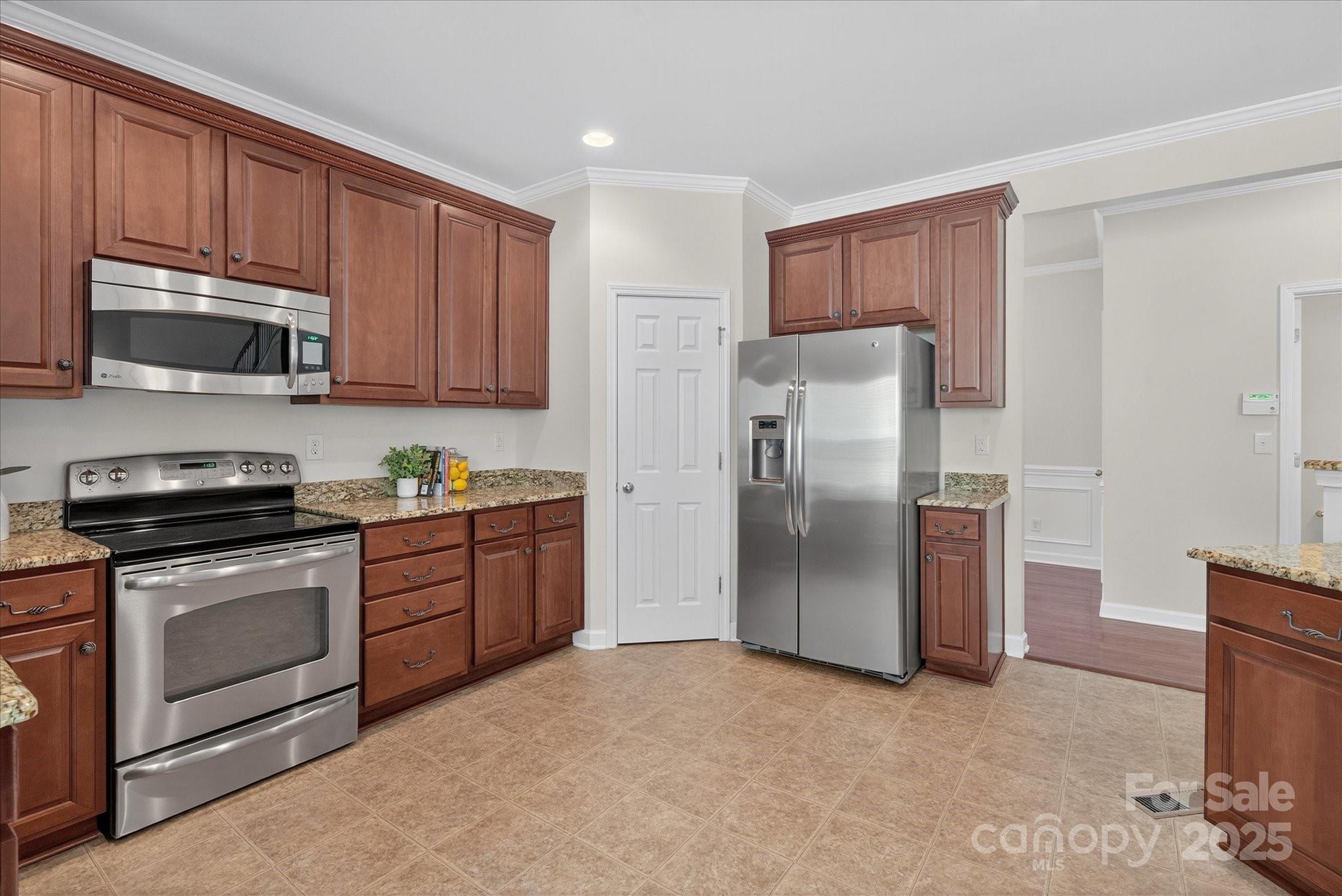 945 Vogel Way Fort Mill, SC 29715 - Photo 18 of 47 a kitchen with stainless steel appliances granite countertop a refrigerator stove a sink and a microwave