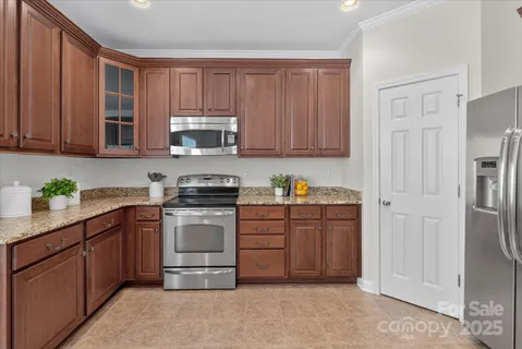 a kitchen with granite countertop wooden cabinets and stainless steel appliances