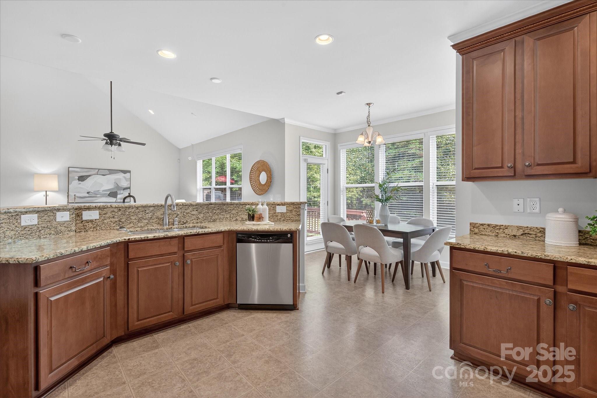 945 Vogel Way Fort Mill, SC 29715 - Photo 20 of 47 a kitchen with granite countertop sink stove and dining table