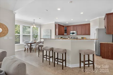 a kitchen with kitchen island granite countertop wooden cabinets and stainless steel appliances