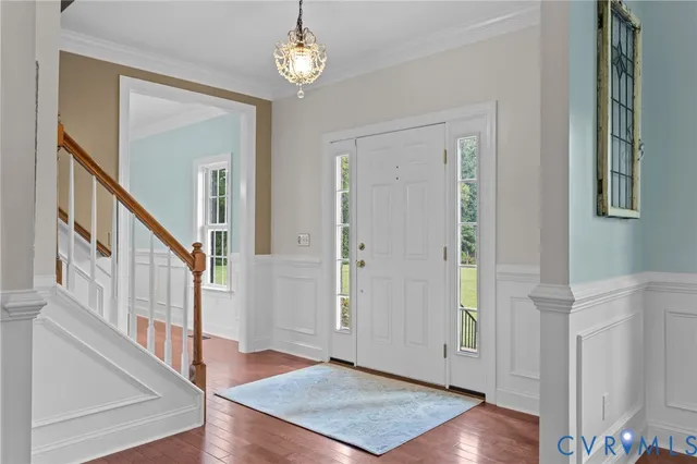a kitchen with a stove a refrigerator and a dining table with wooden floor