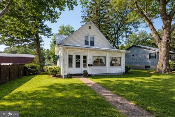 a front view of a house with a yard and trees