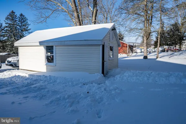 a front view of house with yard outdoor seating and covered with trees