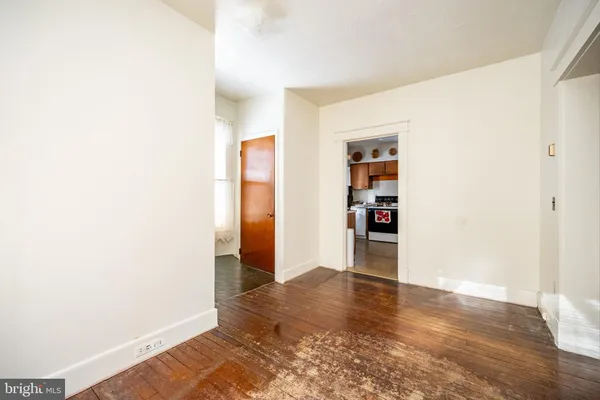 a view of an empty room with wooden floor and closet