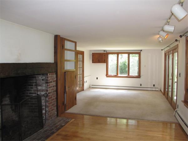 66 Harvard Road Stow, MA 01775 - Photo 7 of 30 a view of an empty room with a fireplace and a window